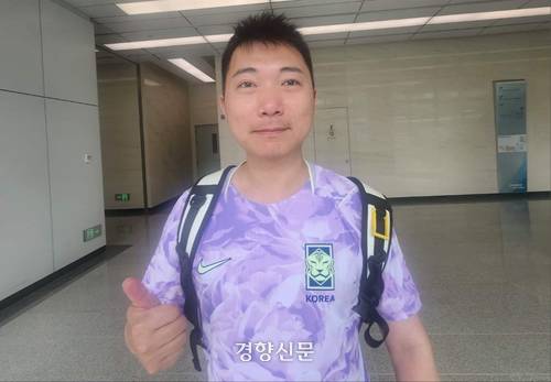 한중 우호수호천사단원인 우캉이 19일 월드컵 공동응원전이 열린 베이징 포스코 센터 복도에서 한국팀을 응원하며 엄지를 들어 보이고 있다.|박은하 특파원