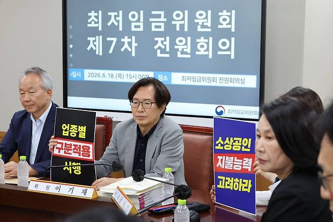 6월18일 정부세종청사&nbsp;최저임금위원회에서 열린 제7차 전원회의에서 사용자 위원들이&nbsp;최저임금의 업종별 구분적용을 요구하는 취지의 손피켓을 들고 있다. ⓒ연합뉴스