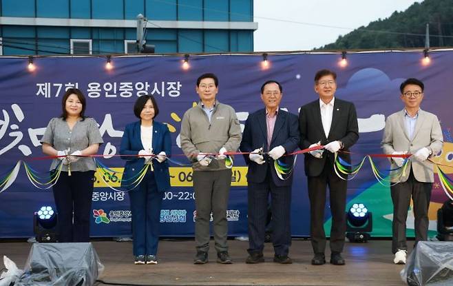 지난 19일 용인중앙시장에서 이상일 시장(왼쪽 세 번째)과 별빛마당 야시장 참석자들이 기념 테이프를 자르고 있다. 용인시 제공