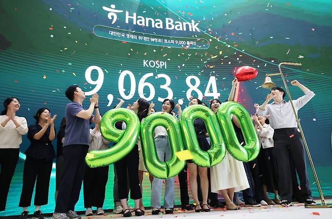 코스피가 사상 첫 9000을 돌파하며 한국 자본시장 역사를 새로 쓴 18일 서울 중구 하나은행 본점 하나인피니티서울에서 직원들이 코스피 9000 돌파 기념 타종 세리머니를 하고 있다. 뉴시스 제공