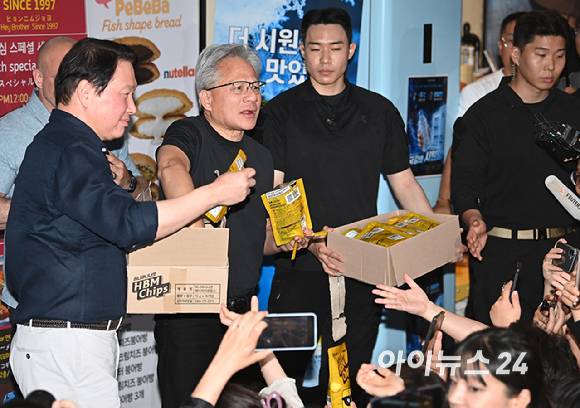 젠슨 황 엔비디아 최고경영자(CEO)가 지난 5일 서울 마포구 서교동의 한 고깃집에서 최태원 SK회장, 구광모 LG회장, 이해진 네이버 의장과 삼겹살 회동에서 시민들에게 HBM 칩을 나눠주고 있다.[사진=곽영래 기자]