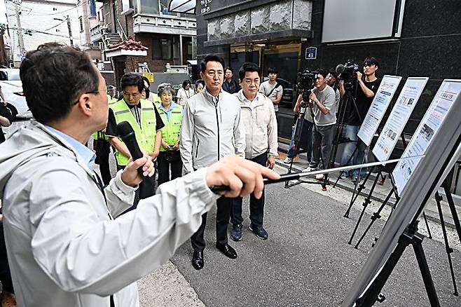 오세훈 서울시장이 22일 관악구 일대에서 풍수해 대비 안전대책 관련 브리핑을 듣고 있다. ⓒ서울시