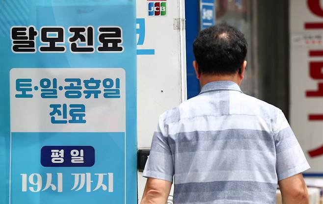 탈모약 건강보험 적용 논의가 급물살을 타면서 재정 부담을 둘러싼 논쟁도 커지고 있다. 정부는 다음 달 4일 탈모치료제 건강보험 급여 적용을 주제로 제1차 모두의 토론회를 열고 국민 여론을 수렴할 예정이다. 사진은 22일 서울의 한 의원에 게시된 탈모진료 안내문. 뉴스1
