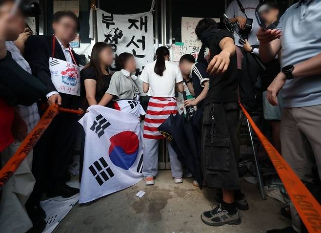 6·3 지방선거 투표용지 부족 사태로 시작한 서울 송파구 올림픽공원 핸드볼경기장 일대 ‘개표소 봉쇄 시위’가 이어진 16일 한 시위 참가자가 문을 가로막아 체육단체 직원들이 경기장 안으로 들어가지 못하고 있다. [연합뉴스]
