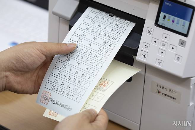 제9회 전국동시지방선거 사전투표 첫날인 5월29일 서울 용산구 이촌1동주민센터에 마련된 사전투표소에서 선거 사무원이 투표용지를 뽑고 있다. ⓒ시사IN 이명익