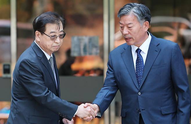 서훈 전 국가안보실장과 김홍희 전 해양경찰청장이 16일 서울 서초구 서울중앙지방법원애서 열린 서해 공무원 피격 사건 관련 허위공문서 작성 및 행사 등 항소심 선고 공판에서 나란히 무죄를 선고받은 후 법정을 나서며 악수를 나누고 있다. 2026.6.16 ⓒ 뉴스1