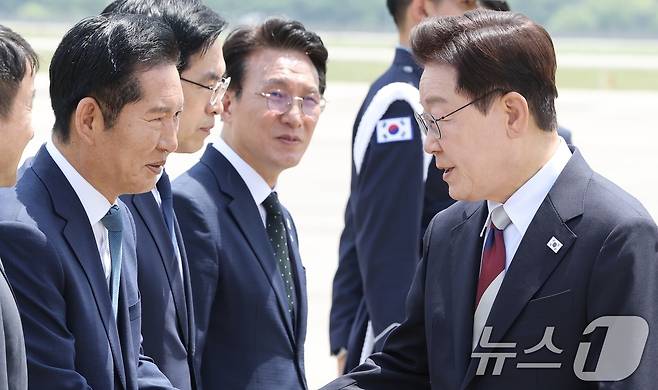 주요 7개국(G7) 정상회의 일정을 마친 이재명 대통령이 18일 경기 성남 서울공항에 도착해 정청래 더불어민주당 대표와 인사를 나누고 있다. 2026.6.18 ⓒ 뉴스1 허경 기자