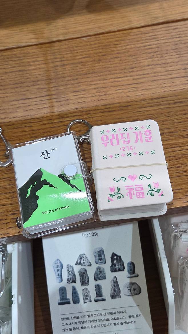 작년 도서전에서 ‘한국에서 가장 아름다운 책’ 대상을 받은 키링북 ‘산239′(왼쪽)를 만든 라이프스타일 브랜드 오이뮤(OIMU)는 올해도 도서전에서 가장 긴 줄을 서는 부스 중 하나였다. 카피라이터 오하림이 가훈으로 쓸 문장 276개를 엮은 키링북 ‘우리집 가훈 276′을 집어 드는 독자가 많았다./박진성 기자
