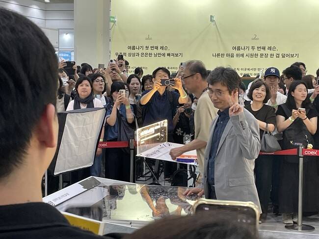 25일 오후 평산책방×돌베개 부스에 들른 유시민 작가. 연호하는 관객들에게 손가락 브이자를 그리며 포즈를 취하고 있다. 이유진 기자
