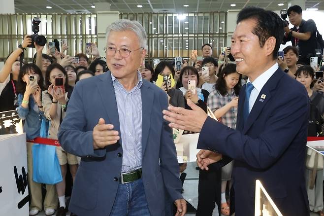 서울국제도서전서 文 만난 鄭 - 정청래(오른쪽) 더불어민주당 대표와 문재인 전 대통령이 24일 서울 강남구 코엑스에서 열린 서울국제도서전에서 만나 시민들에게 둘러싸인 채 인사하고 있다. 연합뉴스