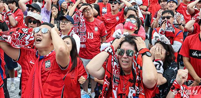 남아프리카공화국과의 2026 북중미 월드컵 조별리그 A조 3차전이 열린 25일 서울 광화문광장에서 거리 응원에 나선 축구 팬들이 한국의 슈팅이 골대를 빗나가자 머리를 감싸 쥐며 안타까워하고 있다. 이한결 기자 always@donga.com