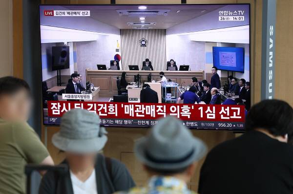 각종 고가 귀금속과 함께 인사·이권 청탁을 받은 이른바 ‘매관매직’ 혐의로 기소된 김건희 여사의 1심 선고가 열린 26일 서울역에서 시민들이 관련 방송을 지켜보고 있다. 연합뉴스
