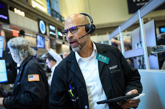 지난 24일(현지 시간) 미국 맨해튼 뉴욕증권거래소(NYSE)의 한 거래중개인이 증시 화면을 살펴보고 있다. 로이터연합뉴스