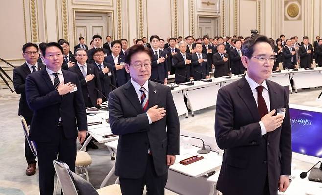 이재명 대통령이 29일 청와대에서 열린 3대 메가프로젝트 국민보고회에서 국민의례를 하고 있다.    오른쪽부터 이재용 삼성전자 회장, 이 대통령, 최태원 SK그룹 회장. 2026.6.29 연합뉴스