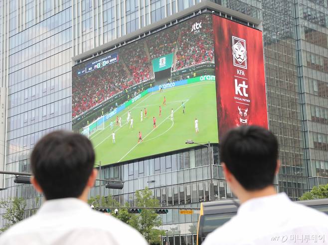 12일 서울 종로구 광화문광장에서 와이셔츠를 입은 시민들이 2026 북중미월드컵 A조 조별리그 1차전 대한민국과 체코의 경기를 대형 미디어월로 지켜보고 있다./사진=뉴스1
