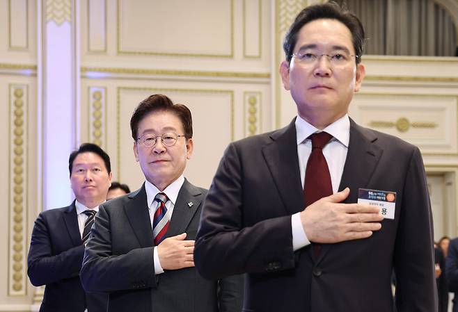 최태원 SK그룹 회장과 이재명 대통령 그리고 이재용 삼성전자 회장(사진 왼쪽부터) 등 참석자들이 29일 청와대 영빈관에서 열린 ‘대한민국 대도약 3대 메가프로젝트 국민보고회’에서 국민의례를 하고 있다. 뉴시스