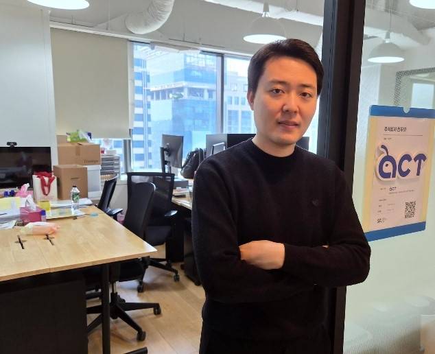 소액주주 연대 플랫폼 ‘액트’를 운영하는 이상목 컨두잇 대표가 회사 로고 옆에서 사무실을 배경으로 팔짱을 낀 채 기념촬영을 하고 있다. 고광본 선임기자
