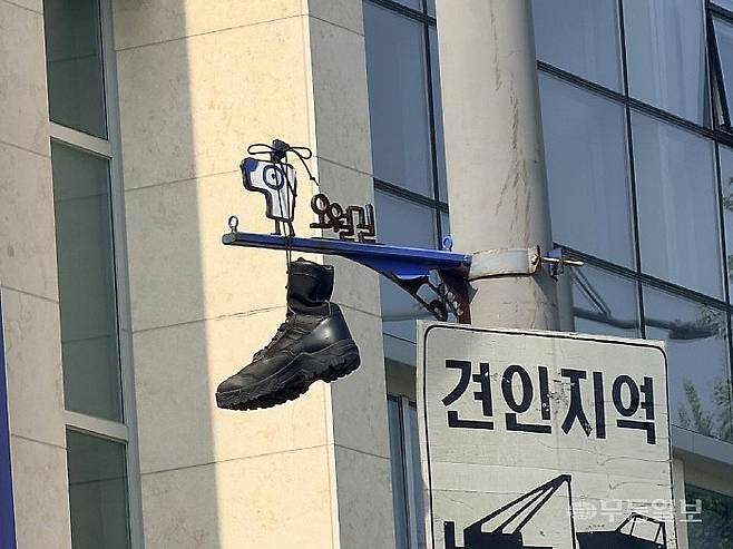 30일 광주 동구 구시외버스터미널(5·18 사적지 제3호) 오월길 안내판 상단 전선에 군화 한 켤레가 걸려 있다. 광주시는 현장 확인 후 군화를 즉시 수거했다. 독자제공