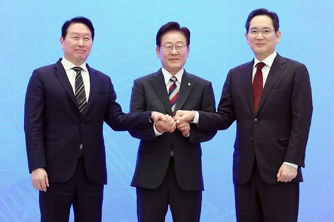 이재명 대통령과 이재용 삼성전자 회장, 최태원 SK그룹 회장이 29일 청와대에서 열린 3대 메가프로젝트 국민보고회에서 기업 투자계획 발표 후 손을 잡고 있다. ⓒ연합뉴스