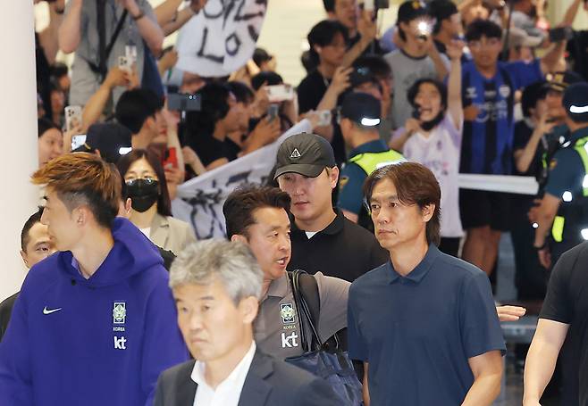▲ 2026 북중미 월드컵 32강 진출에 실패해 한국 축구 국가대표팀에서 사퇴한 홍명보 전 감독이 30일 인천국제공항 제2여객터미널을 통해 입국하며 항의하는 팬들의 현수막을 지나치고 있다. 연합뉴스