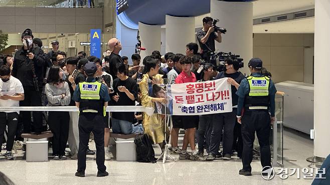 30일 새벽 인천국제공항 제2여객터미널 1층 출국장에서 홍명보 감독을 기다리는 일부 시민들이 홍 감독을 비판하는 현수막을 내걸고 있다. 함현철기자