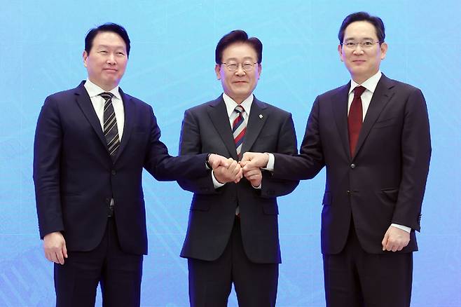 이재명 대통령과 이재용 삼성전자 회장, 최태원 SK그룹 회장이 지난 29일 청와대에서 열린 3대 메가프로젝트 국민보고회에서 기업 투자계획 발표 후 손을 잡고 있다. [청와대통신사진기자단, 연합뉴스]
