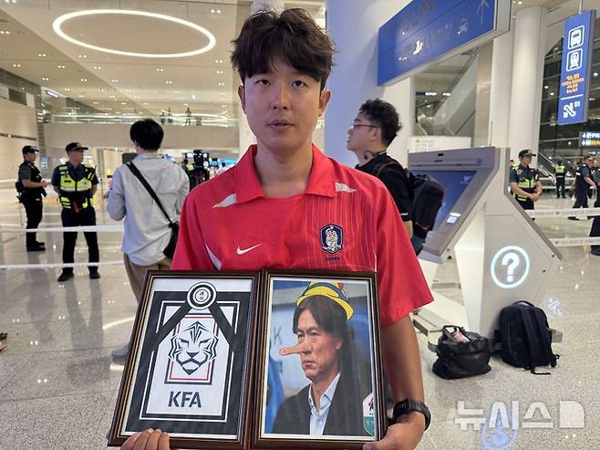 [인천공항=뉴시스] 김진엽 기자= 축구팬 조성근씨가 30일 인천국제공항에서 2026 국제축구연맹(FIFA) 북중미 월드컵 조별리그에서 탈락한 홍명보 전 축구대표팀 감독에 대해 분노하고 있다. wlsduq123@newsis.com 2026.06.30