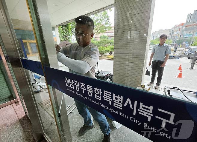 전남광주통합특별시가 출범한 1일 북구청 로비에서 공공청사과 관계자들이 기존 '광주광역시 북구'를 변경된 '전남광주통합특별시 북구'로 교체작업을 하고 있다.(광주 북구 제공. 재판매 및 DB 금지) 2026.7.1 ⓒ 뉴스1