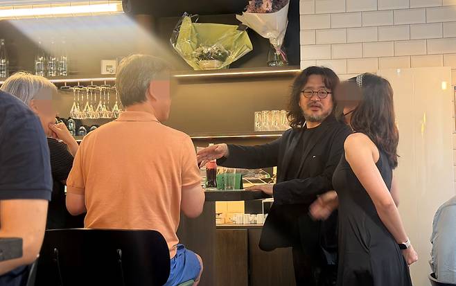 방송인 김어준(58)씨가 지난 30일(현지 시각) 프랑스 파리의 한식당 ‘방드르디 구르망(Vendredi Gourmand·금요 미식회)’ 개업식에서 손님들과 대화하고 있다./원선우 특파원