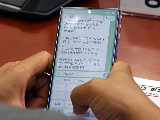 강명구 국민의힘 의원이 지난달 29일 서울 여의도 국회에서 열린 최고위원회의에서 당직자가 보낸 '국민의힘 의원 징계' 관련 문자를 확인하고 있다. 뉴스1