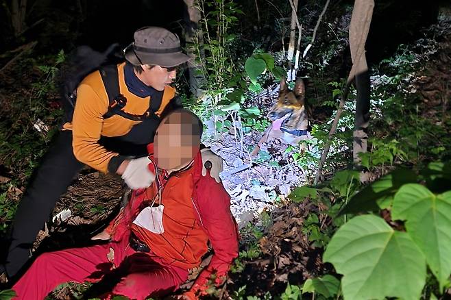 2023년 6월 9일 밤 부산 사하구 다대동 아미산에서 실종됐던 79세 치매 환자를 충성이가 발견한 뒤 구조대원이 환자 상태를 확인하고 있다. 사진 부산소방재난본부