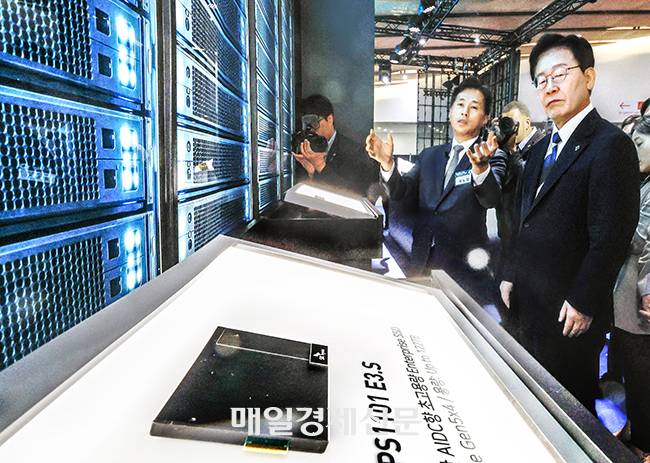 이재명 대통령이 30일 전남광주특별시 김대중컨벤션센터에서 열린 서남권 첨단산업 발전 비전 국민보고회에 앞서 곽노정 SK하이닉스 사장(왼쪽)으로부터 인공지능(AI) 데이터센터에 사용되는 초고용량 솔리드스테이트드라이브(SSD) 제품인 PS1101에 관한 설명을 듣고 있다. 이날 삼성그룹 AI 반도체 전시물 등을 관람하고 있다. 이날 삼성·SK 등은 서남권에 총 896조원을 투자하겠다는 계획을 밝혔다. [광주 김호영 기자]
