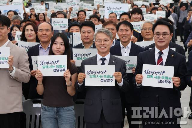 ▲민형배 전남광주통합특별시장이 1일 오후 동구 5·18민주광장에서 열린 '전남광주통합특별시 출범식 및 반도체 투자환영 시민대회'에서 '압도적 성장! 함께 사는 특별시 전남광주'라고 적힌 손팻말을 들고 기념 사진을 찍고 있다.2026.07.01ⓒ독자
