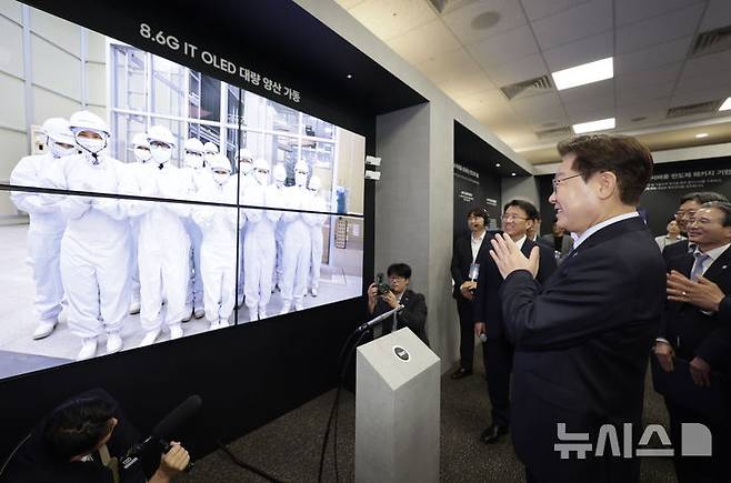 [아산=뉴시스] 최동준 기자 = 이재명 대통령이 2일 충남 아산시에서 열린 충청권  첨단산업 발전비전 국민보고회에서 삼성디스플레이를 통해 생산라인 엔지니어들을 격려하고 있다. 2026.07.02. photocdj@newsis.com