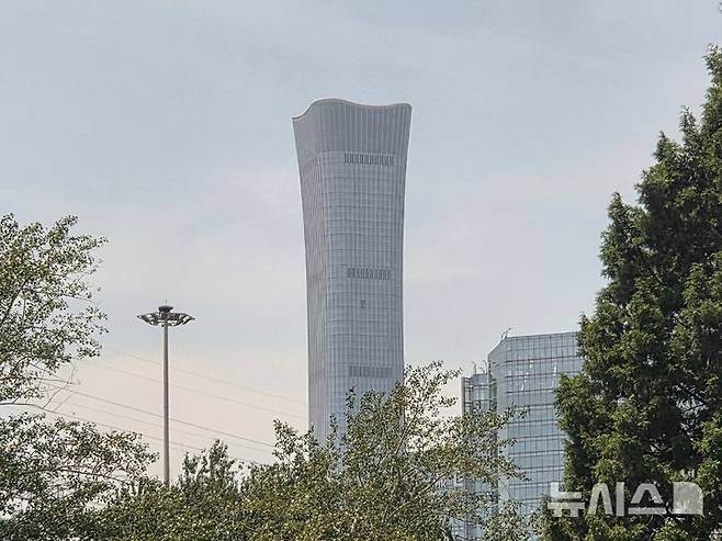 [베이징=뉴시스] 박정규 특파원 = 지난 26일 오후 경비행기 충돌 사고가 발생한 중국 베이징 시내 초고층빌딩인 중신그룹 본사 건물의 27일 모습. 빌딩 중앙에 경비행기가 충돌해 유리 외벽 일부가 파손된 모습이 보인다. 2026.06.29 pjk76@newsis.com