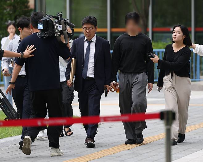 잠실 개표소 봉쇄 시위 첫날 경찰관을 폭행한 혐의를 받는 20대 남성이 2일 서울 송파구 동부지법에서 열린 영장실질심사에 출석하기 위해 법정으로 향하고 있다. 연합뉴스