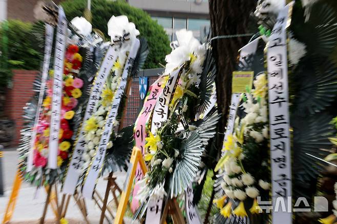 [서울=뉴시스] 권창회 기자 = 1일 오후 서울 강동구 배재고등학교 정문 앞에 근조화환이 늘어 서 있다.지난달 29일 배재고는 청룡기 전국고교야구선수권대회 광주제일고와의 경기에서 "가야지, 가야지, 스타벅스 가야지", "탱크 데이"등 스타벅스의 '5·18 탱크데이' 논란을 연상시키는 구호를 외쳤다. 2026.07.01. kch0523@newsis.com
