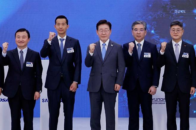 이재명 대통령(가운데)이 3일 경남 진주시에서 열린 ‘영남권 첨단산업 발전비전 국민보고회’에 참석해 투자협약식을 마친 뒤 기념촬영을 하고 있다. 왼쪽부터 노태문 삼성전자 사장, 김동관 한화그룹 부회장, 이 대통령, 장재훈 현대차그룹 부회장, 정재헌 SK텔레콤 사장. [청와대사진기자단]
