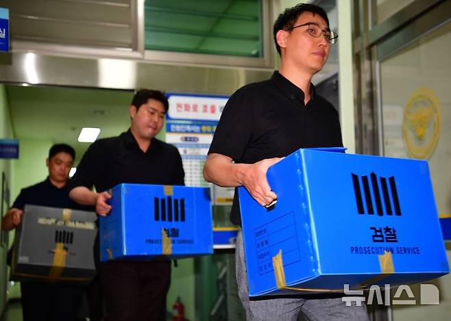 [전남광주=뉴시스] 양시원 기자 = 장윤기(23) 여고생 살인사건의 부실수사와 경찰 유착 의혹을 수사하는 광주지검 수사관들이 7일 오후 전남광주통합특별시 광주광산경찰서에 대한 압수수색을 마치고 압수물이 담긴 상자를 들고 나오고 있다. 2026.07.07. goodwrite97@newsis.com