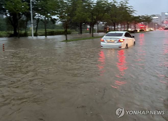 범람한 도로, 멈춘 차량 (대전=연합뉴스) 9일 대전 유성구 자운동 한 도로에 차량이 범람한 물 때문에 오가지 못하고 있다. 119 구조대원이 이 차량에서 2명을 구조했다고 대전시는 전했다. 전날부터 대전에는 강한 비가 이어졌다. 2026.7.9 [대전시 제공. 재판매 및 DB 금지] walden@yna.co.kr