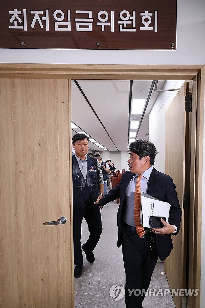 다음주로 미뤄진 내년 최저임금 결정 (세종=연합뉴스) 김주성 기자 = 권순원 최저임금위원장이 9일 정부세종청사 최저임금위원회에서 열린 제13차 전원회의를 마친 뒤 나오며 근로자위원인 류기섭 한국노총 사무총장과 대화하고 있다. 2026.7.9 utzza@yna.co.kr