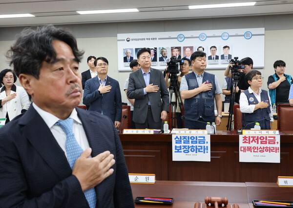 7일 정부세종청사 최저임금위원회에서 열린 제12차 전원회의에서 권순원 위원장과 근로자·사용자 위원들이 국기에 경례하고 있다. 2026. 7. 7 연합뉴스
