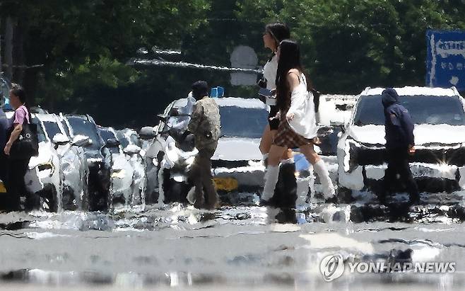 펄펄 끓는 도심 (대구=연합뉴스) 윤관식 기자 = 대구에 폭염 경보가 발효된 11일 대구 중구 공평네거리에서 시민들이 지열로 인한 아지랑이가 피어오르는 도로 위를 지나가고 있다. 2026.7.11 psik@yna.co.kr