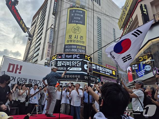 장동혁 국민의힘 대표가 12일 오후 부산 부산진구 서면 하트광장에서 열린 시민운동 현장에 참석해 대형 태극기를 흔들고 있다. 2026.07.12.ⓒ 뉴스1 조유리 기자.