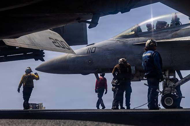 USS 에이브러햄 링컨 비행갑판에서 제41전투비행대대(VFA 41) 소속 F/A-18F 슈퍼 호넷 전투기를 활주로에서 정비하는 미 해군 장병들. /연합뉴스