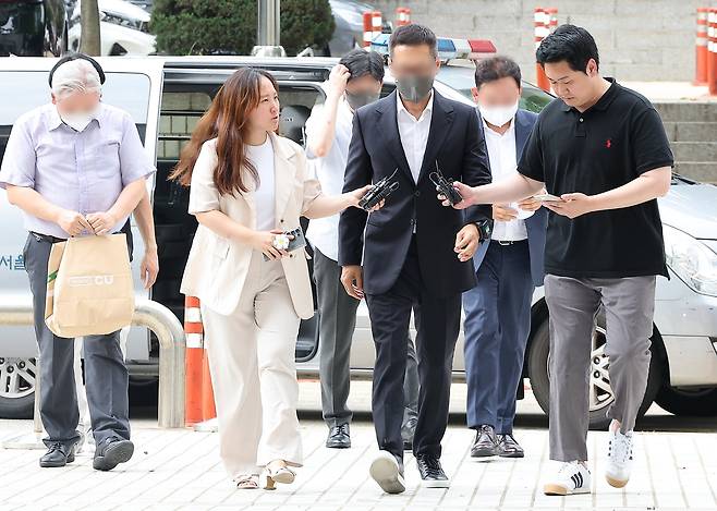 이화전기의 주식 거래 정지 의혹을 받는 김영준 이그룹(옛 이화그룹) 회장(왼쪽 네 번째), 김성규 총괄 사장(왼쪽 다섯 번째)을 비롯한 경영진들이 26일 오후 자본시장과 금융투자업에 관한 법률 위반 혐의로 서울중앙지방법원에서 열린 구속 전 피의자 심문(영장실질심사)에 출석하고 있다. 2024.8.26/뉴스1