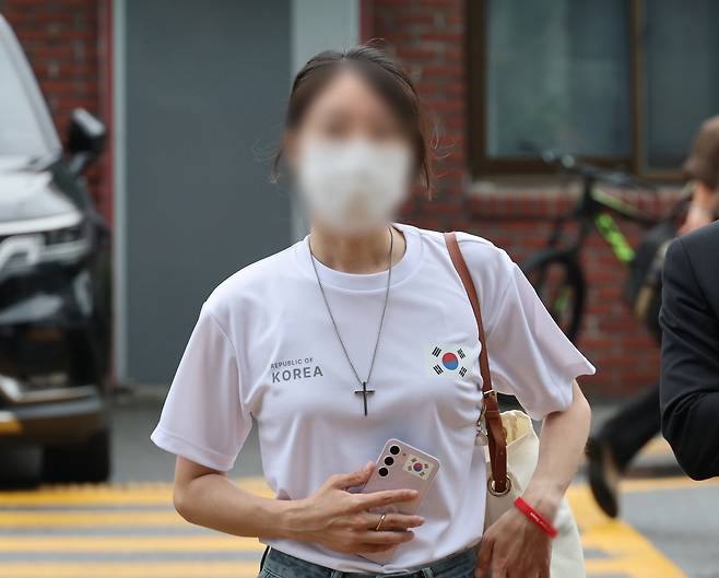 올림픽공원 핸드볼경기장 문 앞에서 체육단체 직원들의 장내 사무실 진입을 막아 업무 방해 혐의를 받는 30대 여성이 지난 10일 서울 송파경찰서에서 조사받기 위해 출석하고 있다. 연합뉴스