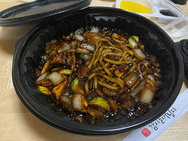 검정 플라스틱 용기에 담긴 짜장면.[챗GPT로 제작된 이미지]