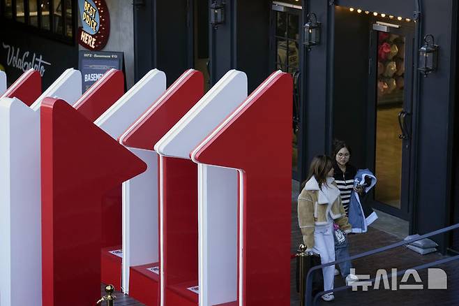 [베이징=AP/뉴시스] 중국 내수시장이 심각한 소비부진을 겪는 가운데 중국 연중 최대 쇼핑축제인 '광군제(11월 11일)' 분위기가 냉랭한 것으로 알려졌다. 사진은 지난 4일 11월11일 조형물이 세워진 베이징의 쇼핑몰에서 두 고객이 걸어가는 모습. 2024.11.11