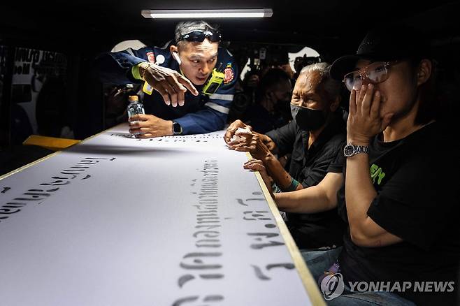 방콕 화재 참사 희생자의 관과 유족 (방콕 AFP=연합뉴스) 14일(현지시간) 태국 방콕의 병원에서 술집 화재 참사의 희생자 유족들이 관을 붙잡고 통곡하고 있다.
